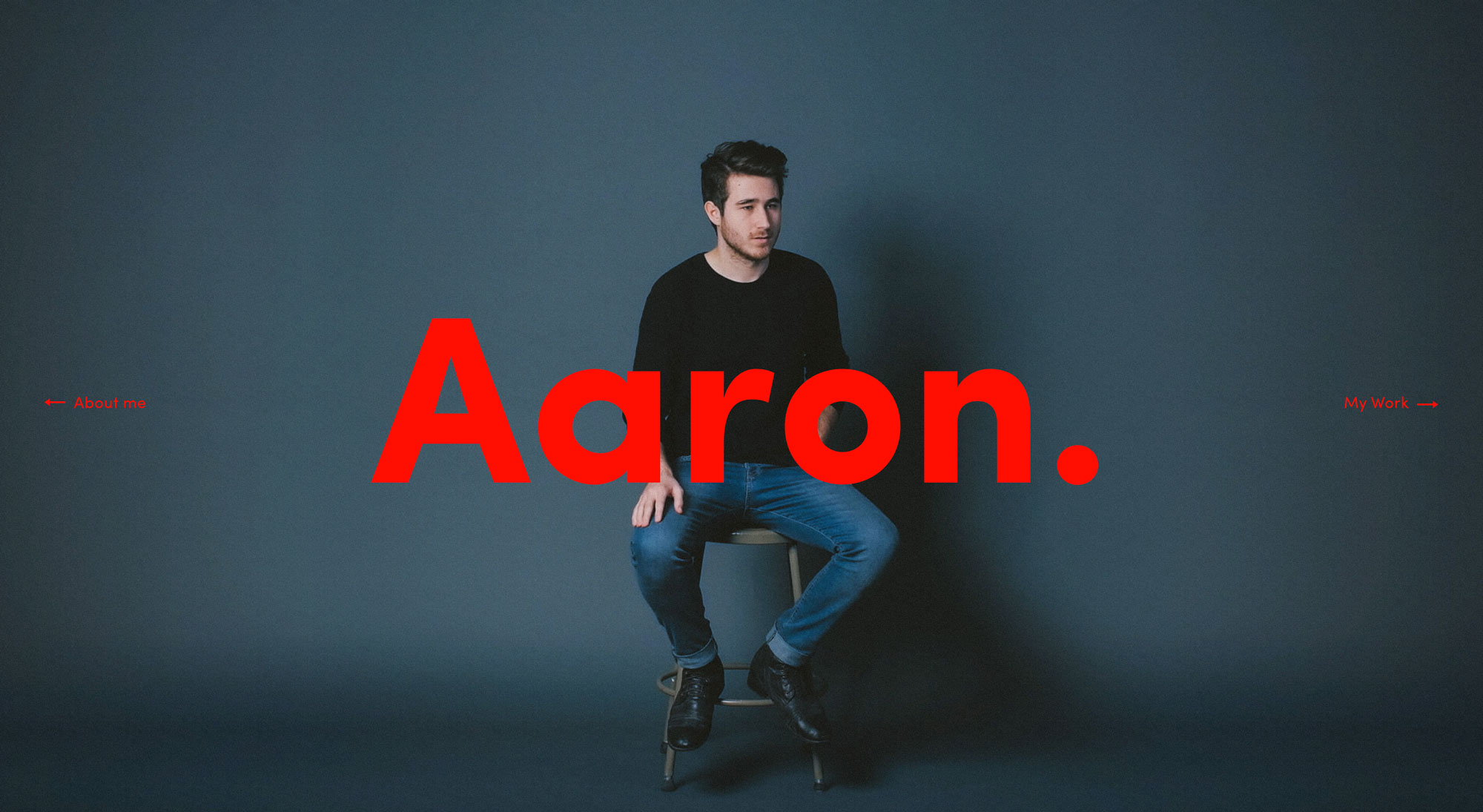 Man sitting on a stool with the text 'Aaron.' on top of the image